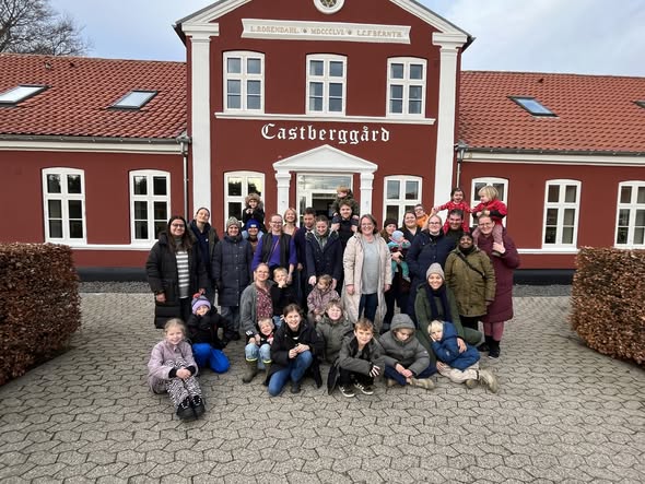 Familier i Hånd om Sproget samlet foran Castberggård — voksne og børn på tværs af generationer.
